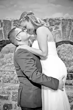 Brautpaar umarmt sich liebevoll und schaut sich lächelnd in die Augen.