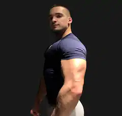 Sportlicher Mann posiert seitlich vor dunklem Hintergrund.