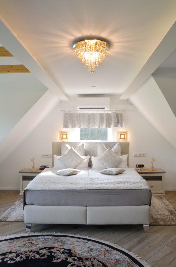 Gemütliches Schlafzimmer mit Doppelbett und Kronleuchter.